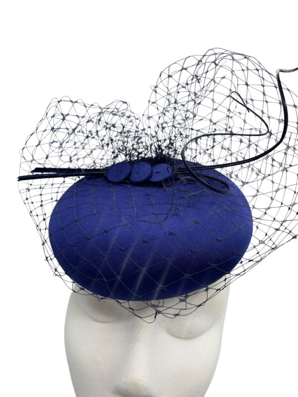 Simple beautiful navy headpiece with navy veiling overlay and finished with matching navy quills.